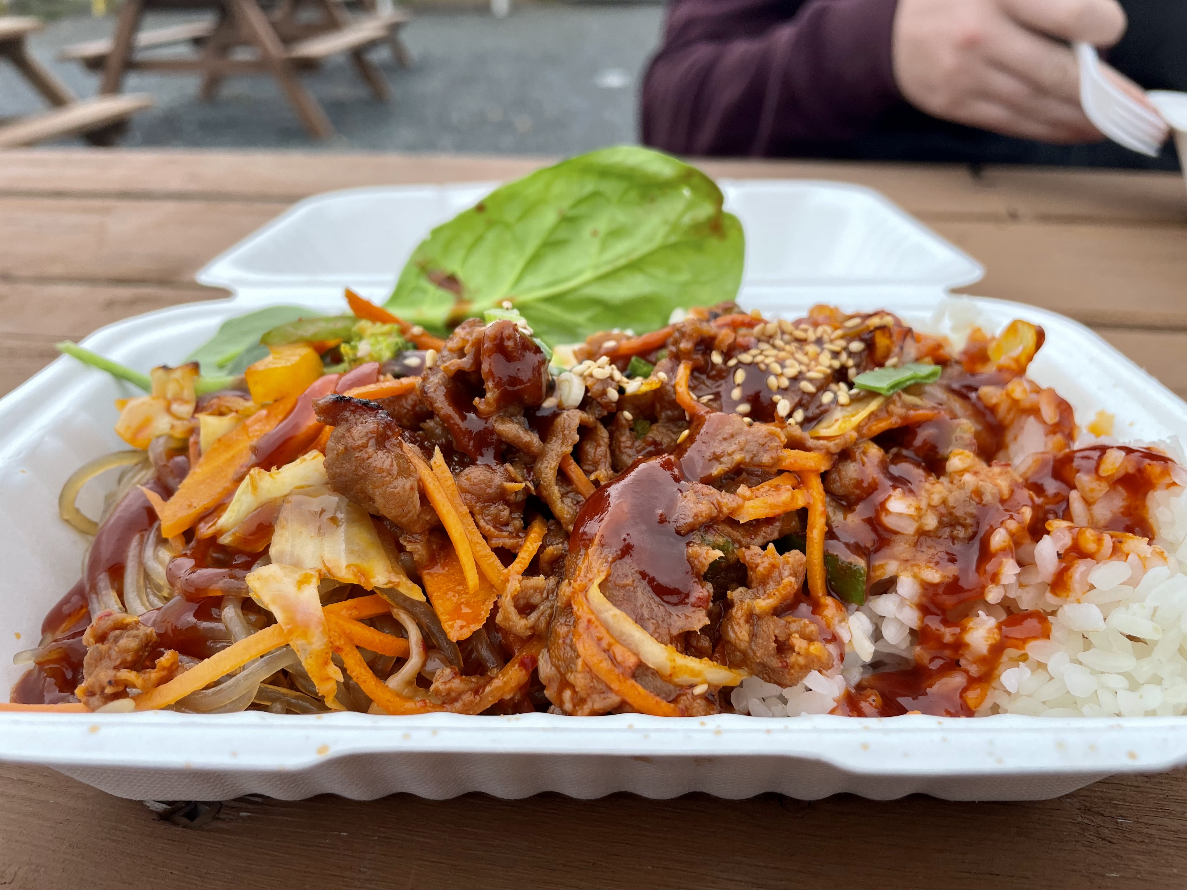 Tender pork stir-fried with japchae noodles, rice, and crisp vegetables in a rich gochujang sauce