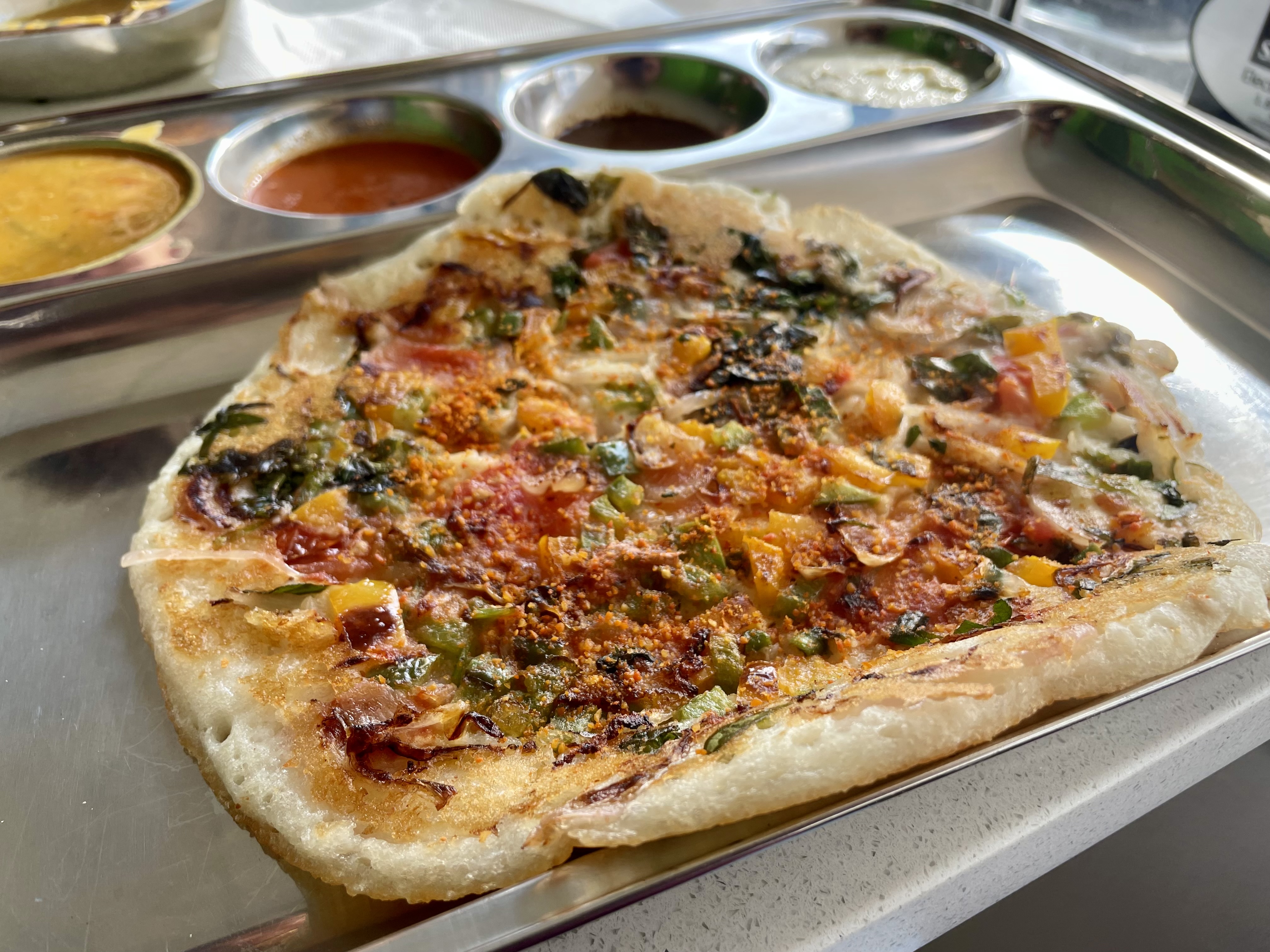 Unlike a typical dosa, which is crisp and crepe-like, an uttapam is thicker, with toppings
