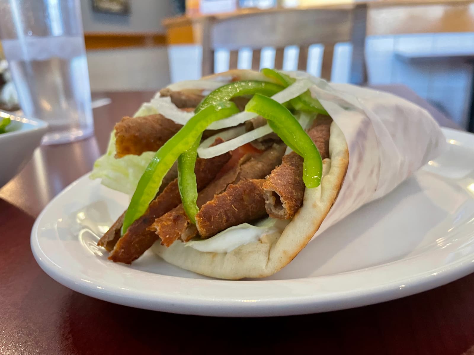 A warm, overstuffed donair with crispy-edged meat and creamy tzatziki wrapped in soft pita