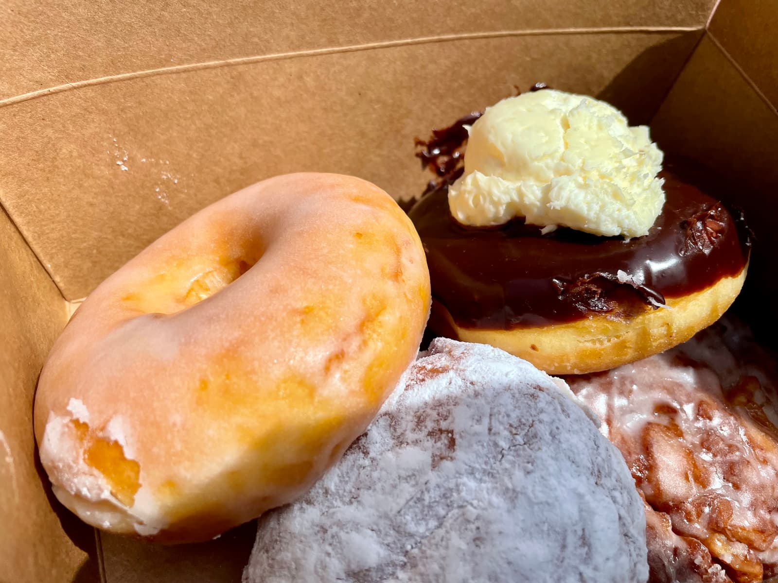 Apple fritter with a crisp edge and a soft centre, finished with a nuanced icing that pulls everything together and Boston cream donut built on a rich filling and a well-structured dough that holds its shape throughout