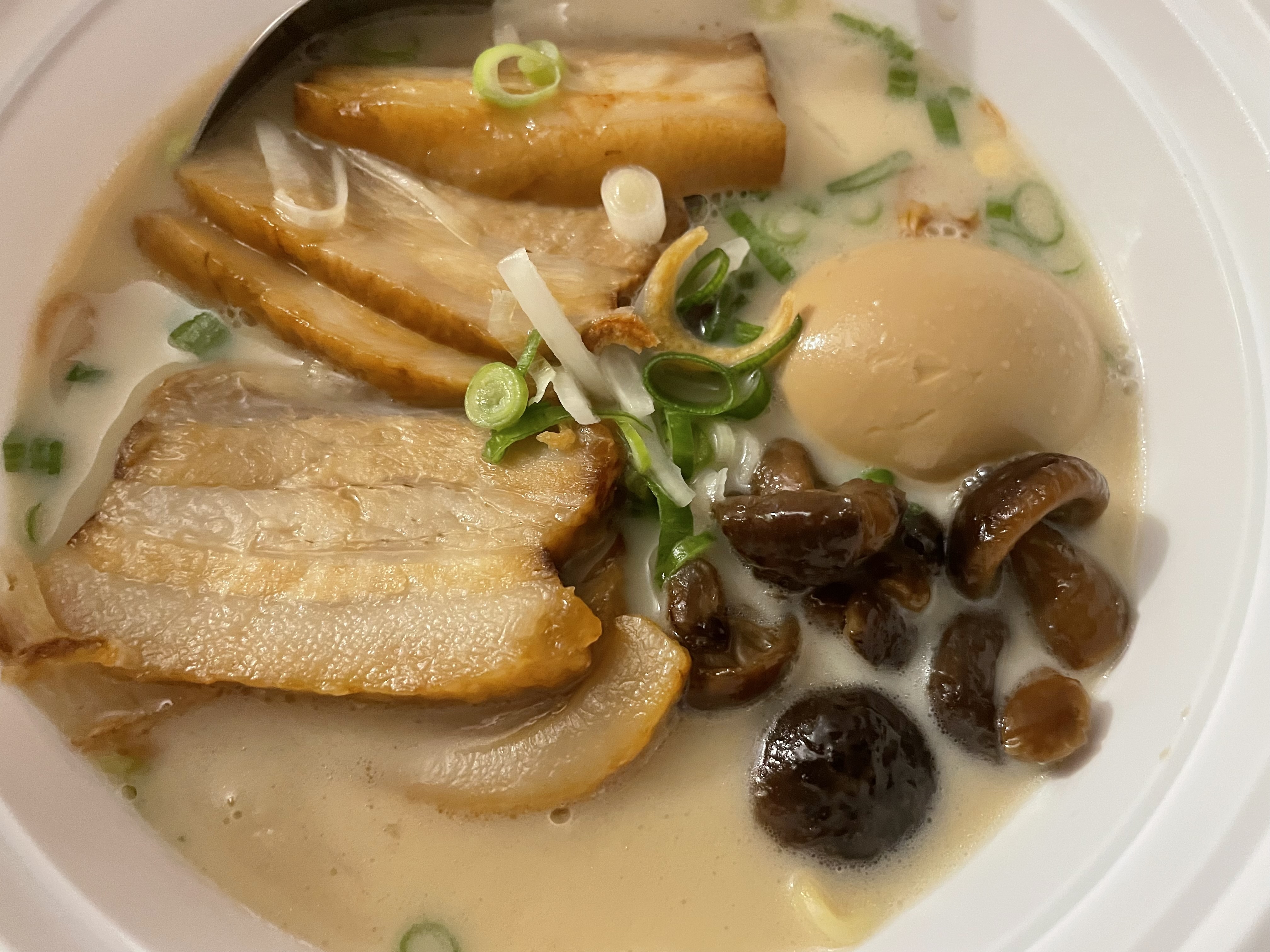 The tonkotsu ramen was served with chashu, shiitake mushrooms, soya sauce, a braised egg and green onions