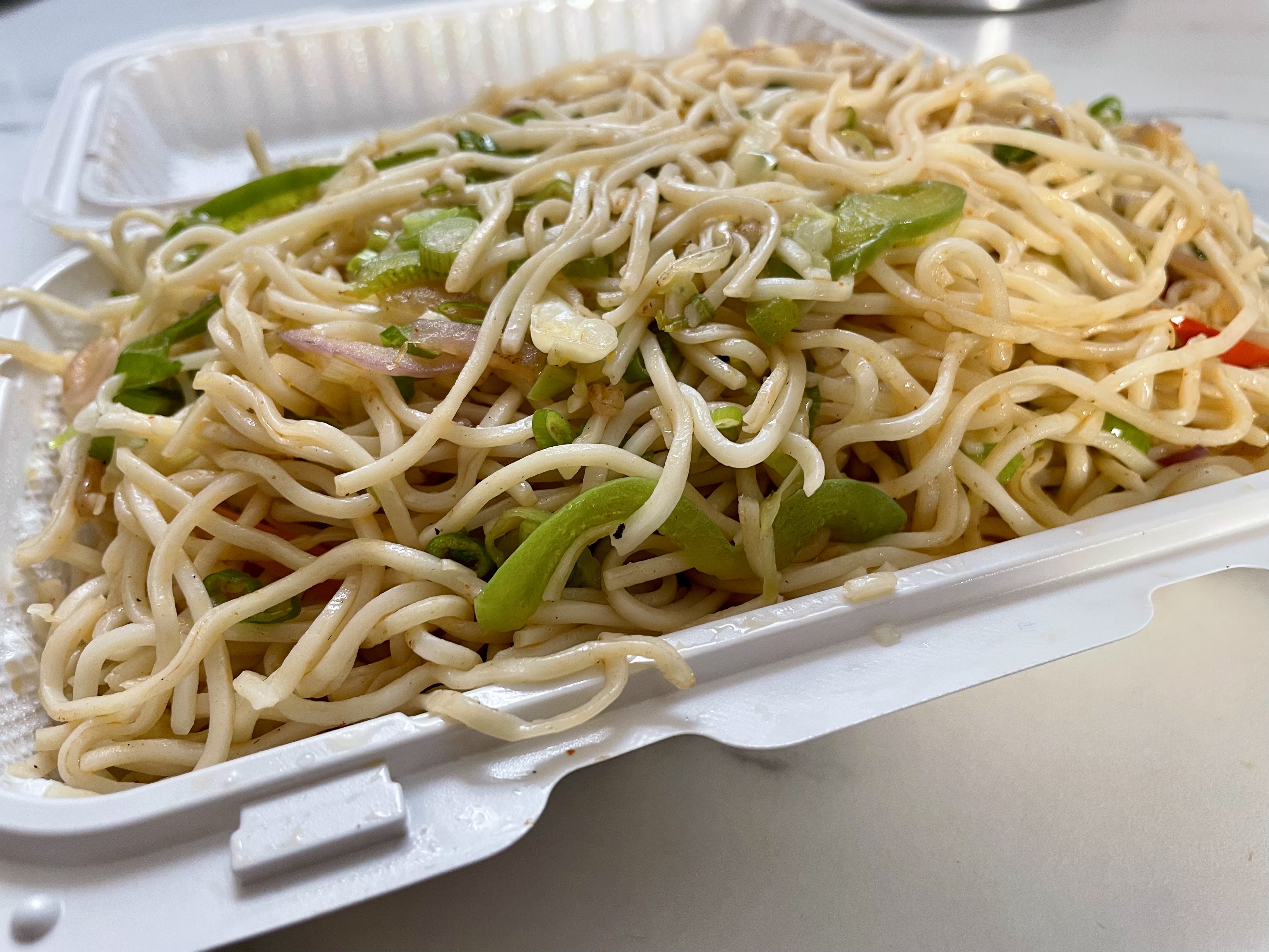Delicate yet firm noodles stir-fried with a harmonious blend of soy sauce, garlic, and black pepper, complemented by crunchy vegetables, offering a comforting balance of savoury and spicy notes.