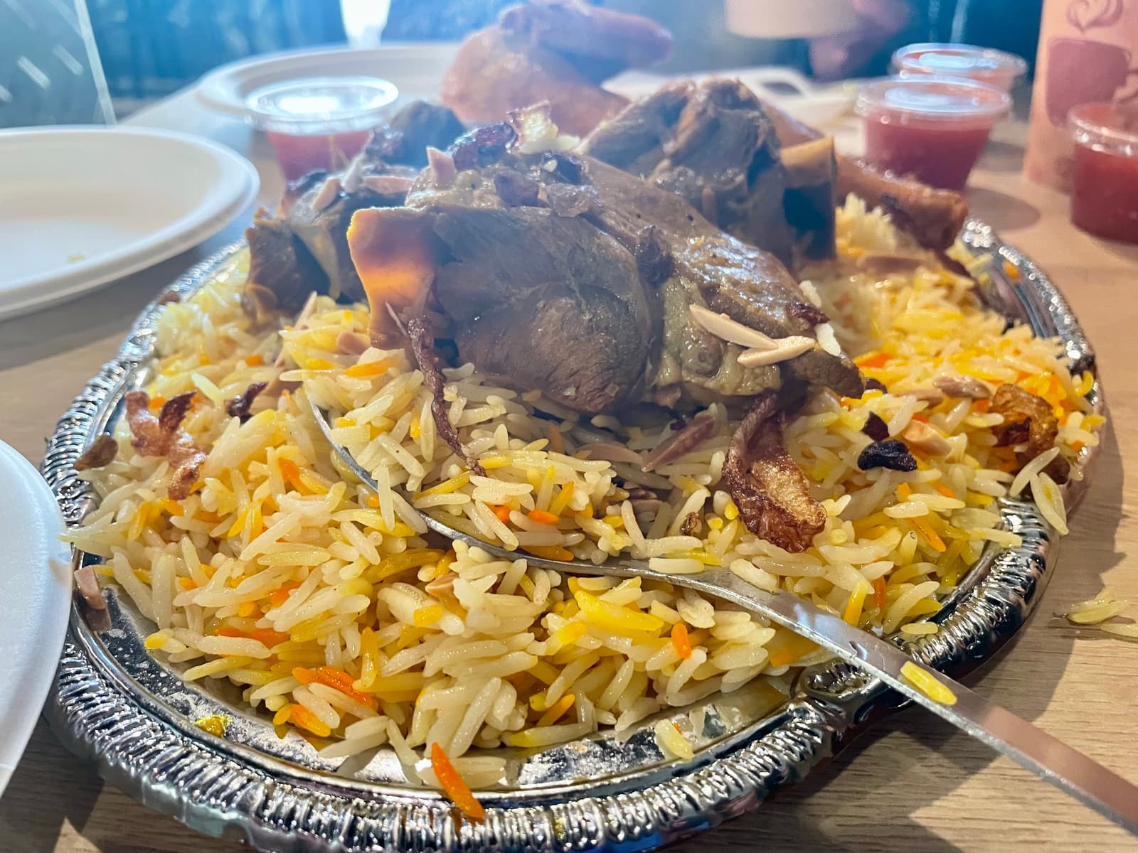 A generous platter of perfectly seasoned rice, fall-apart lamb, and juicy chicken—topped with crispy onions, sweet raisins, and roasted almonds