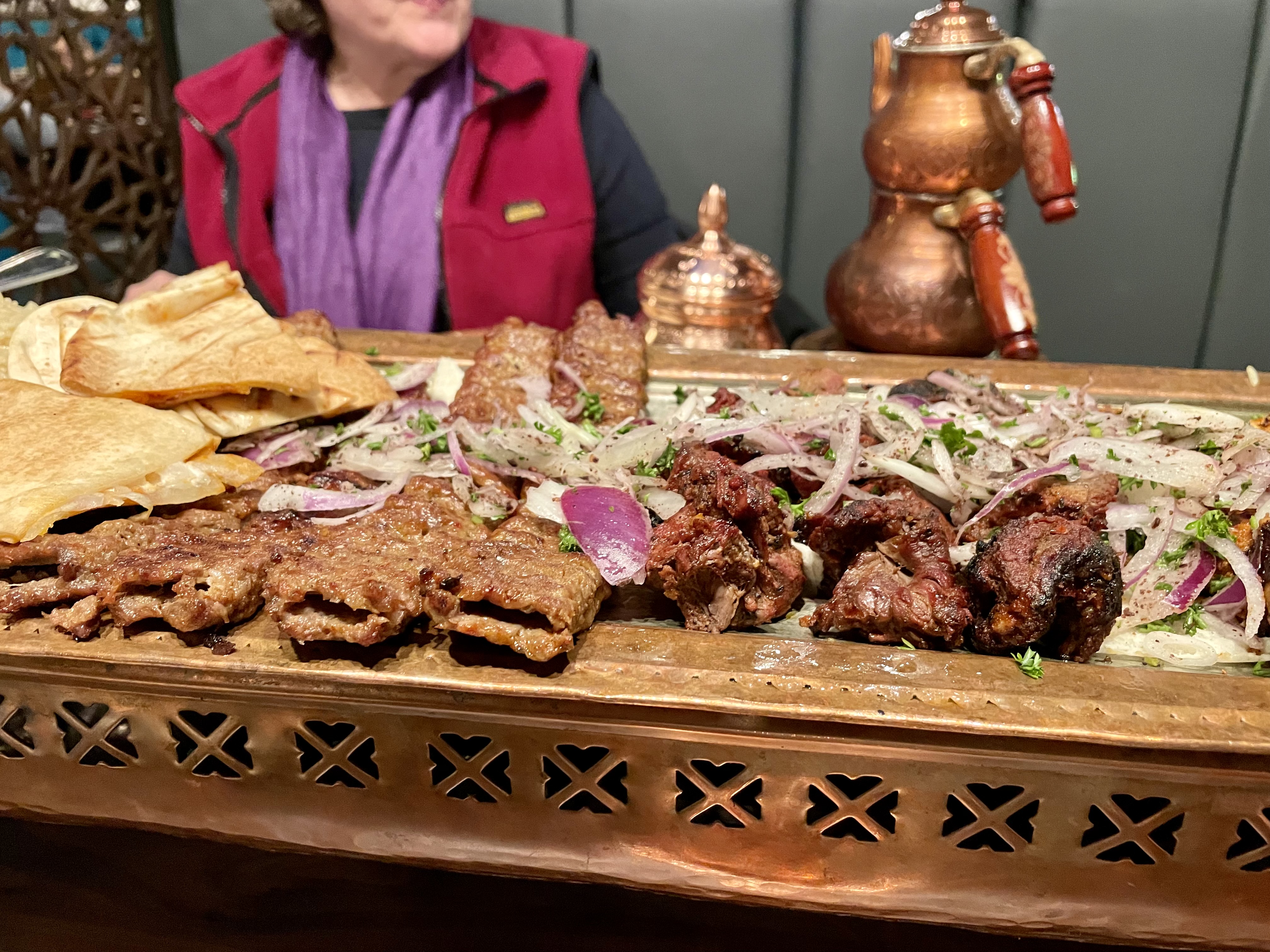 The platter arrived shortly after evening prayers ended and the dining room, filled with families, dug into their meals as the servers brought out even larger platters of perfectly grilled meats, rice, breads and vegetables from the kitchen 