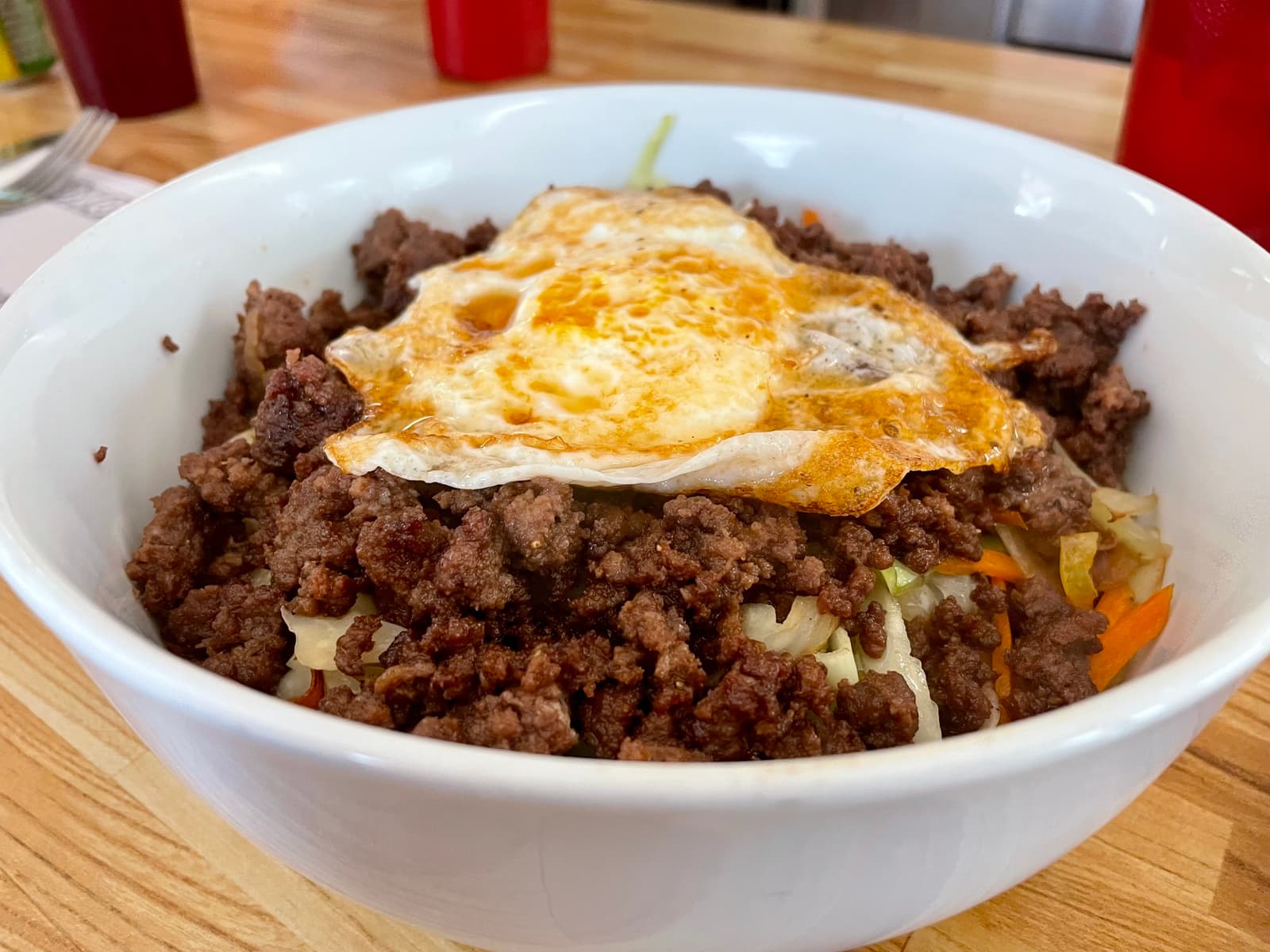 A sizzling bowl of beef, crisp vegetables, fried egg, and sesame oil—Korean comfort food served from the heart of a northside diner